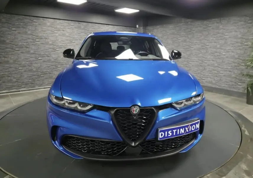 Vue frontale d'une Alfa Romeo Tonale 2025 bleu métallisé avec calandre noire et phares LED distinctifs.