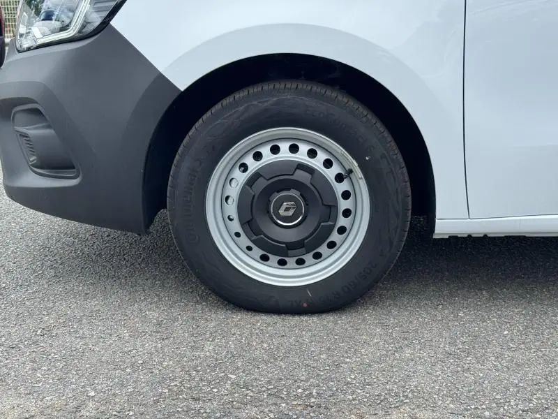 Gros plan sur la roue avant gauche blanche d’un Renault Kangoo Van avec jante acier et logo Renault visible.