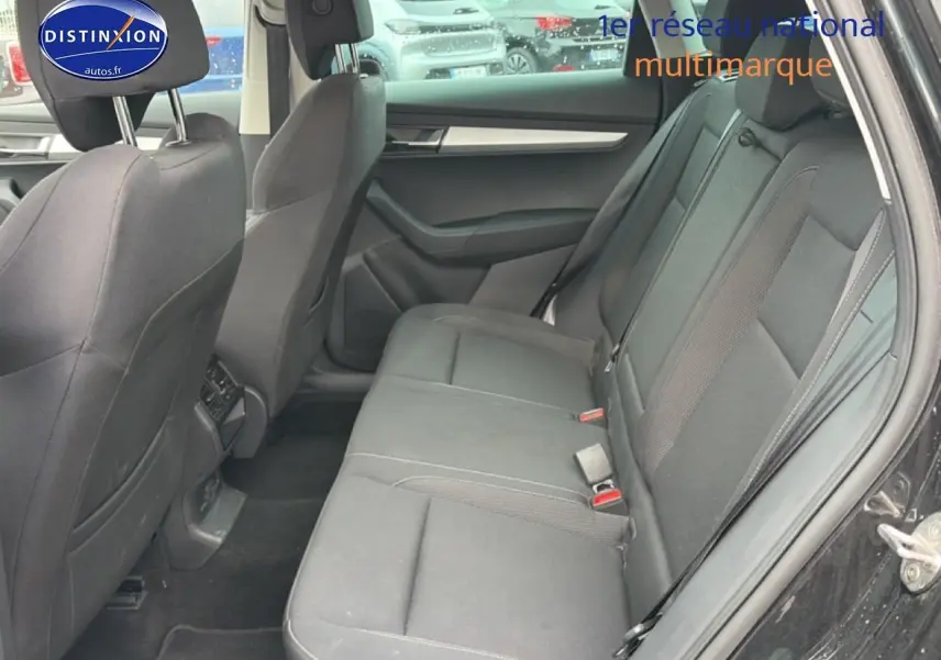 Vue intérieure côté droit montrant la banquette arrière noire du Skoda Karoq 2025, avec portes ouvertes.