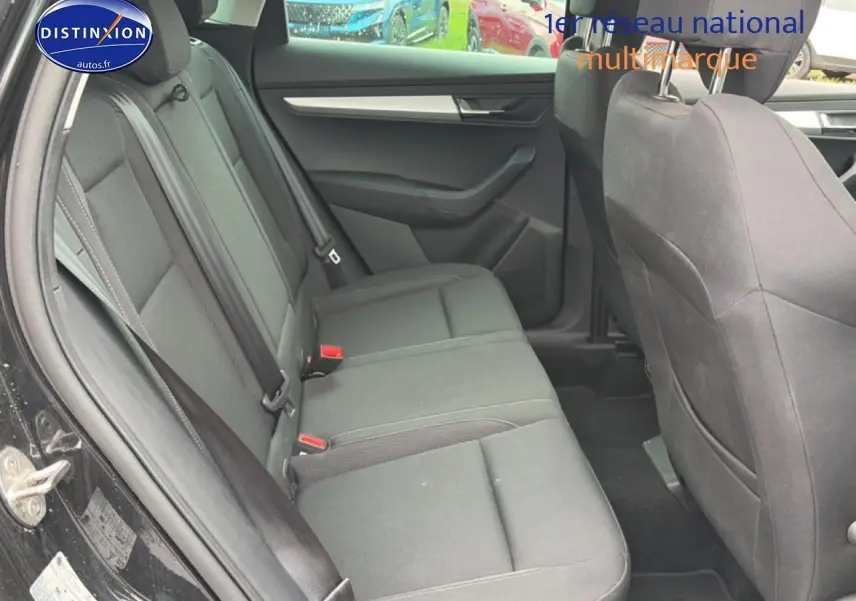 Vue intérieure côté gauche montrant la banquette arrière noire du Skoda Karoq 2025 avec ceintures et portes ouvertes.