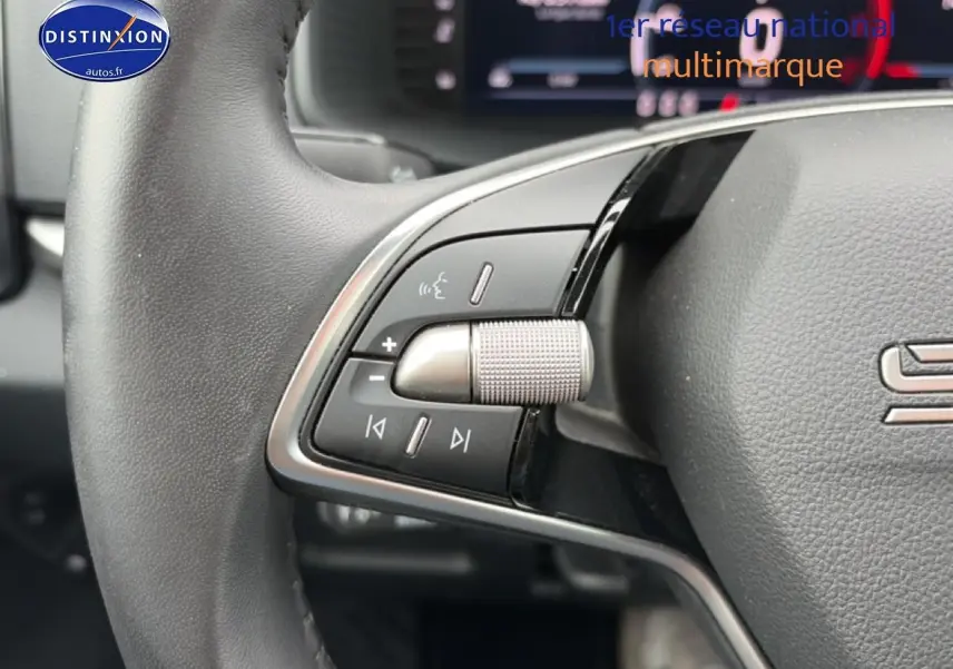 Gros plan sur les commandes audio au volant cuir noir du Skoda Karoq 2025, avec molette et boutons multifonctions.