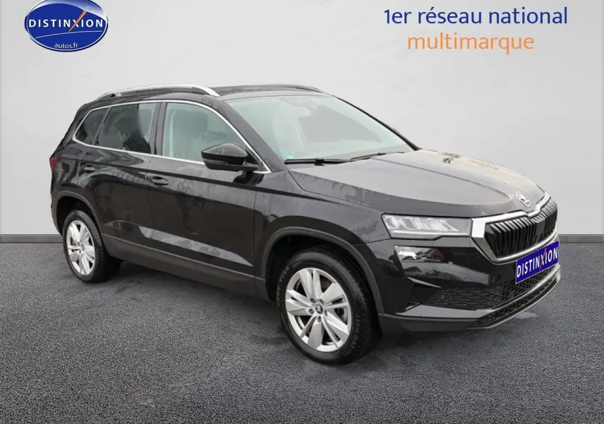SUV Skoda Karoq noir vu en 3/4 avant droit avec jantes alu et barres de toit visibles.