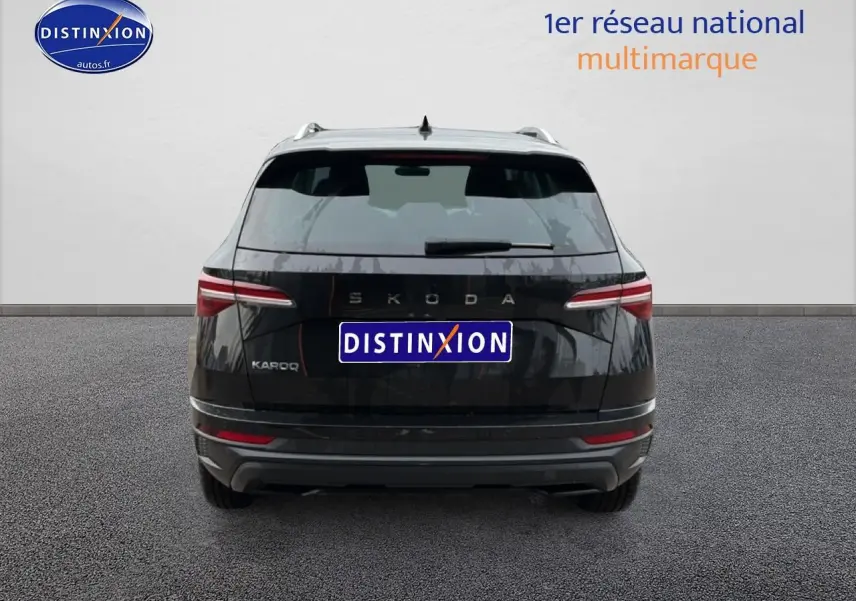 Vue arrière d'un Skoda Karoq noir 2025 avec feux LED et logo distinctif sur fond neutre.
