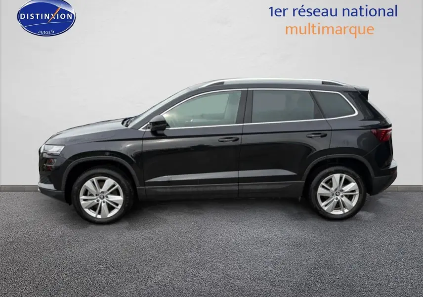 Profil droit d'un Skoda Karoq noir 2025 avec jantes alu et barres de toit visibles sur fond neutre.