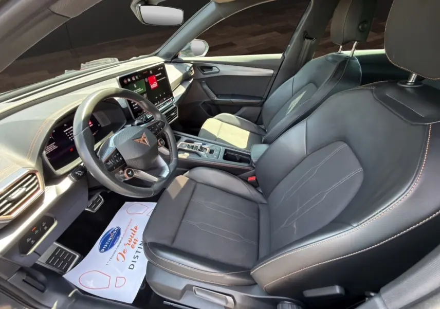 Vue intérieure côté conducteur du CUPRA Formentor 2025, sièges cuir noir et tableau de bord avec écran tactile central.