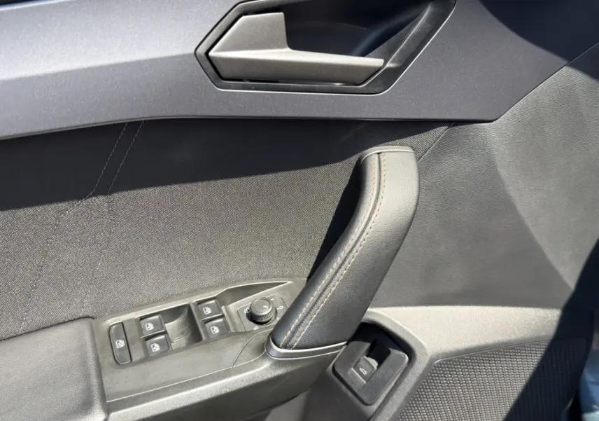 Détail de la porte intérieure côté conducteur gris foncé avec commandes électriques et poignée cuir sur CUPRA Formentor 2025.