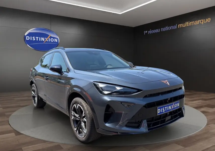 Vue 3/4 avant droit d'une CUPRA Formentor gris foncé avec jantes noires et logo cuivre sur calandre.