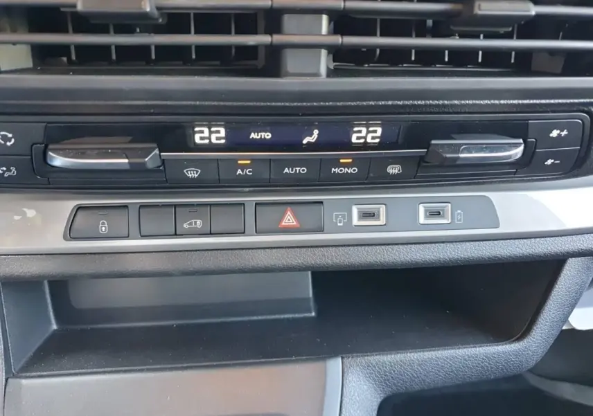 Détail du tableau de bord du Toyota Proace Fourgon blanc glacier, montrant les commandes de climatisation et ports USB.