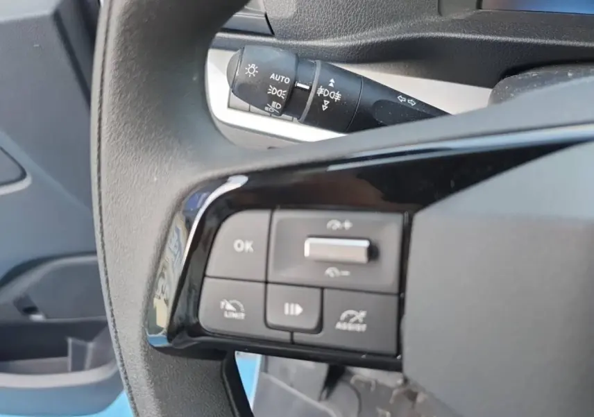Gros plan sur les commandes au volant à gauche du Toyota Proace Fourgon blanc Glacier, avec levier de clignotants en arrière-plan.