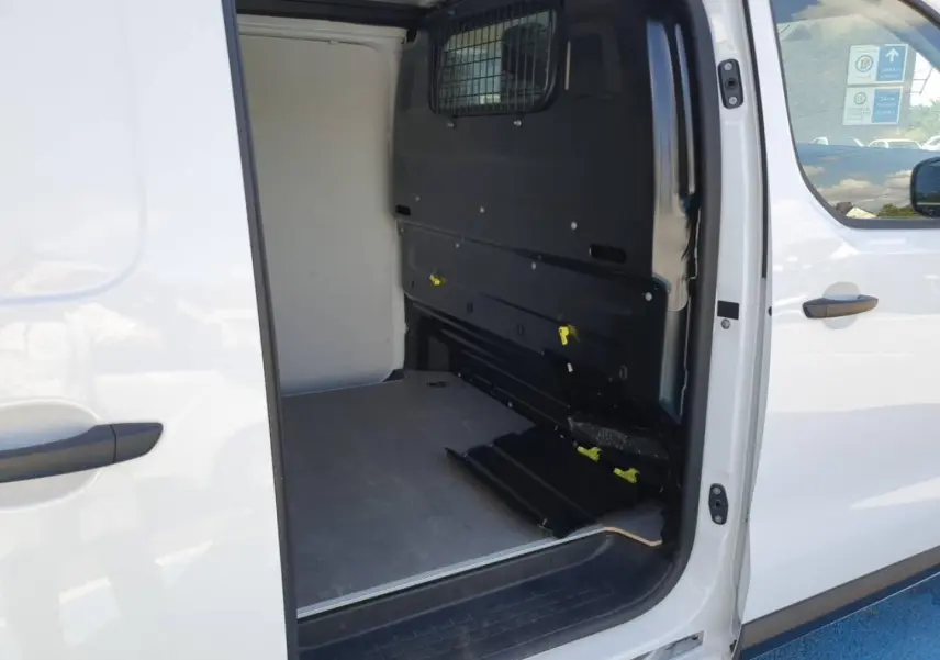 Vue latérale droite du Toyota Proace Fourgon blanc Glacier avec porte coulissante ouverte sur l'espace de chargement vide.