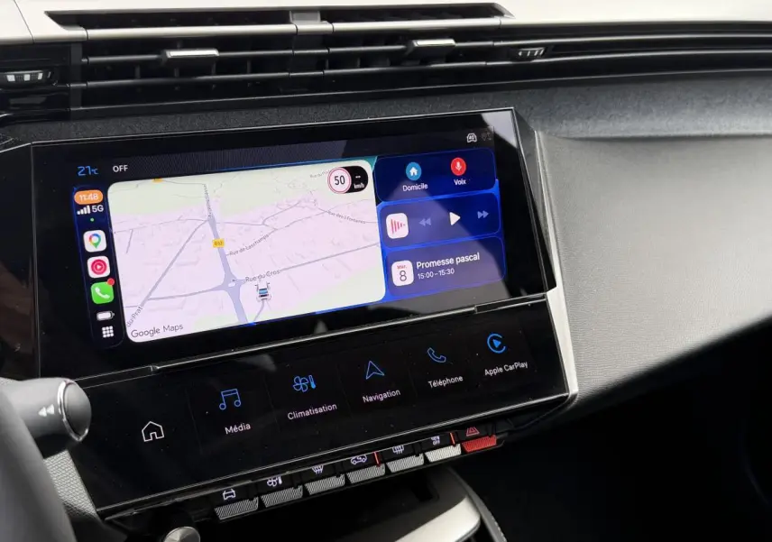 Vue rapprochée de l’écran tactile central du Peugeot 308 SW 2024 rouge, affichant la navigation et les commandes multimédias.