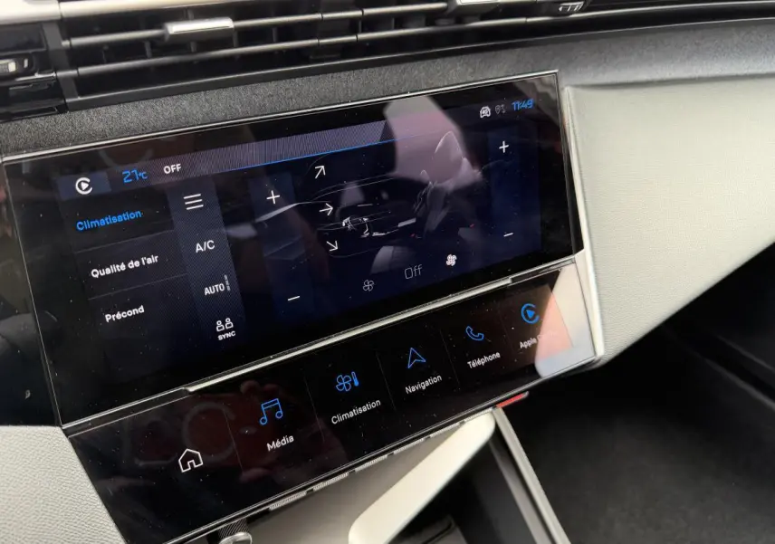 Écran tactile central de la Peugeot 308 SW 2024 en vue rapprochée, affichant les commandes de climatisation et multimédia.