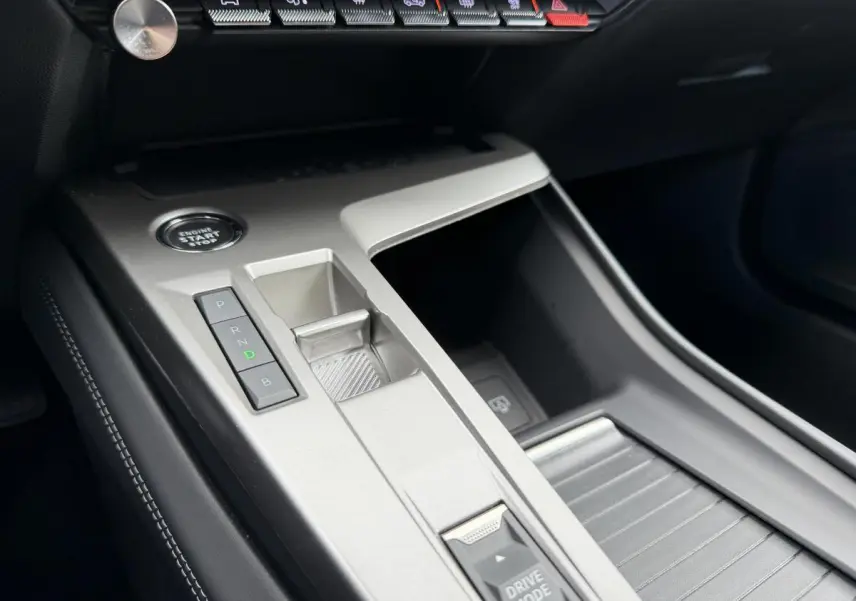 Vue rapprochée de la console centrale argentée avec boutons de boîte auto et bouton start dans une Peugeot 308 SW rouge.