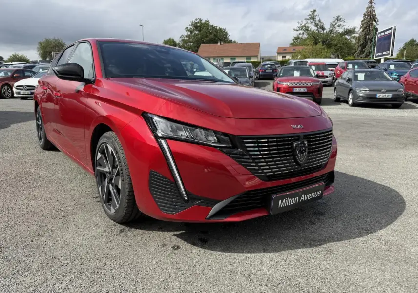 Peugeot 308 SW rouge Elixir vue 3/4 avant droit, calandre noire avec logo lion et phares LED distinctifs.
