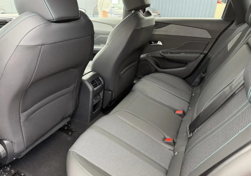 Vue intérieure arrière côté droit de la banquette grise avec surpiqûres bleues et prises USB C sur Peugeot 308 SW 2024.