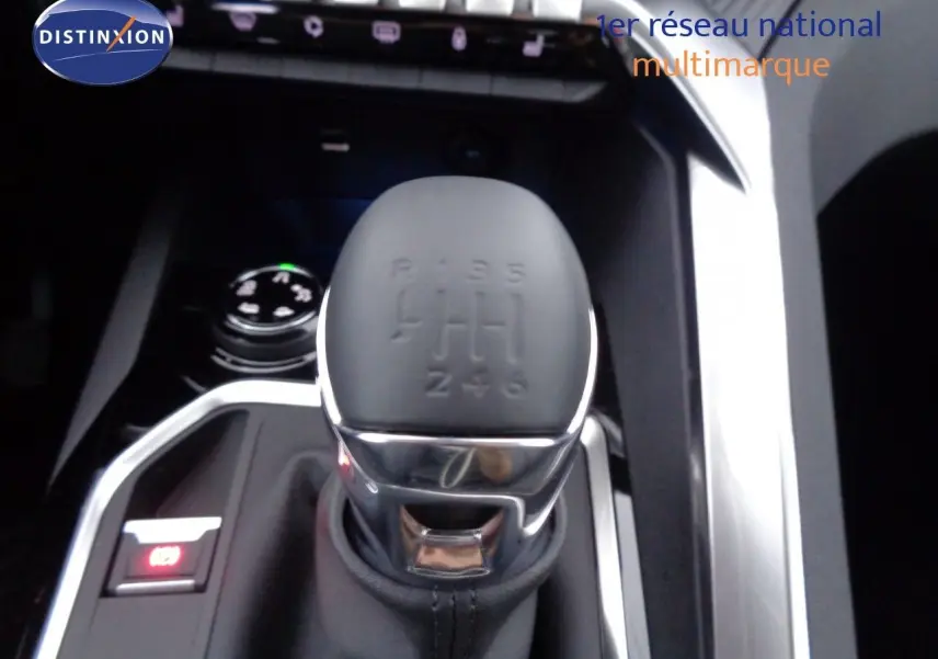 Le levier de vitesses manuel gris mat du Peugeot 3008 2023, entouré d'inserts chromés et d'un bouton de frein à main électronique.