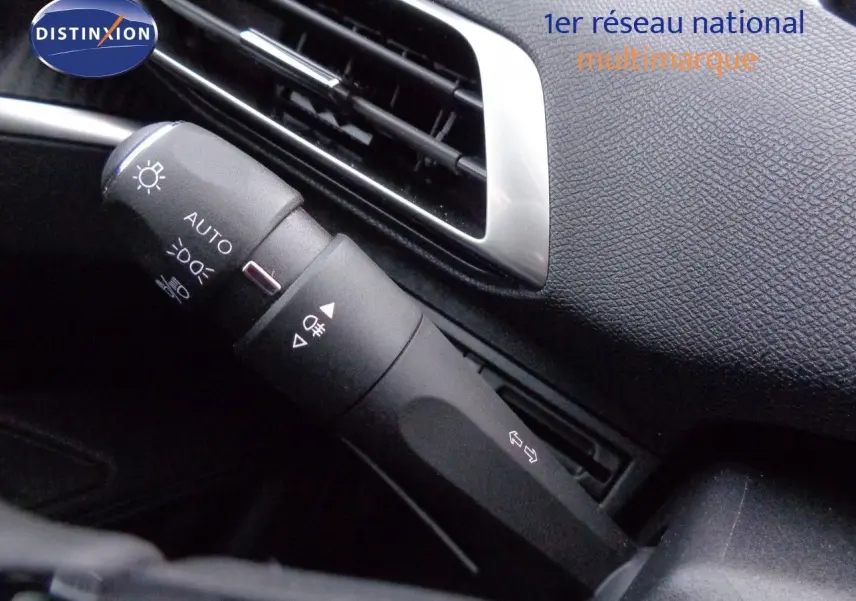 Gros plan sur la commande des feux et clignotants dans l'habitacle noir du Peugeot 3008 2023.