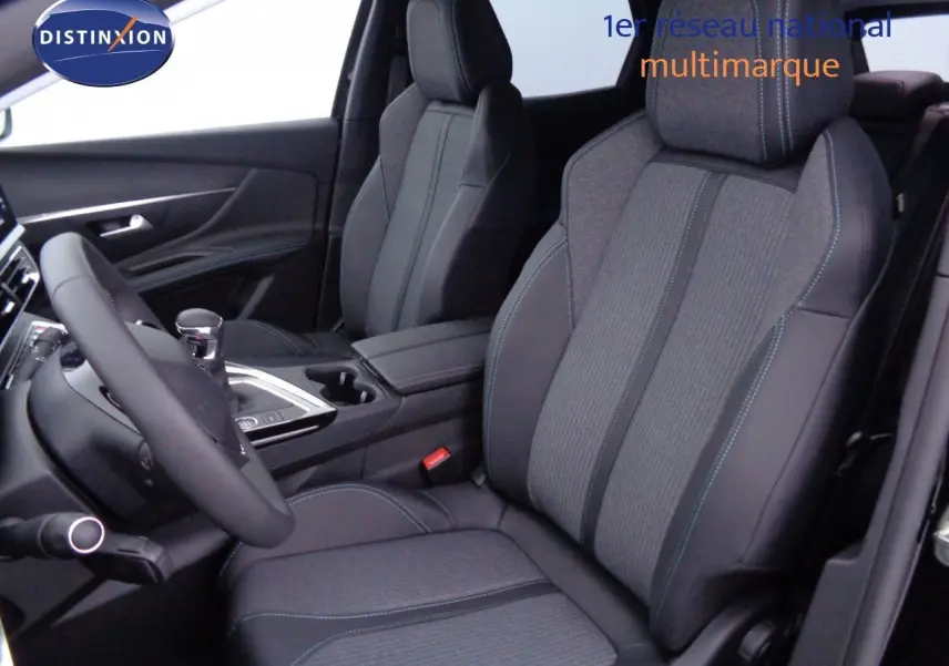 Vue intérieure côté conducteur du Peugeot 3008 2023, sièges en tissu gris et cuir noir avec surpiqûres bleues.