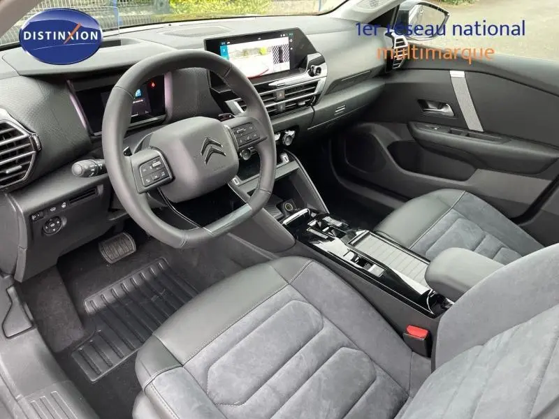 Intérieur avant de la Citroën C4 gris, vue côté conducteur, volant cuir et écran tactile central lumineux.