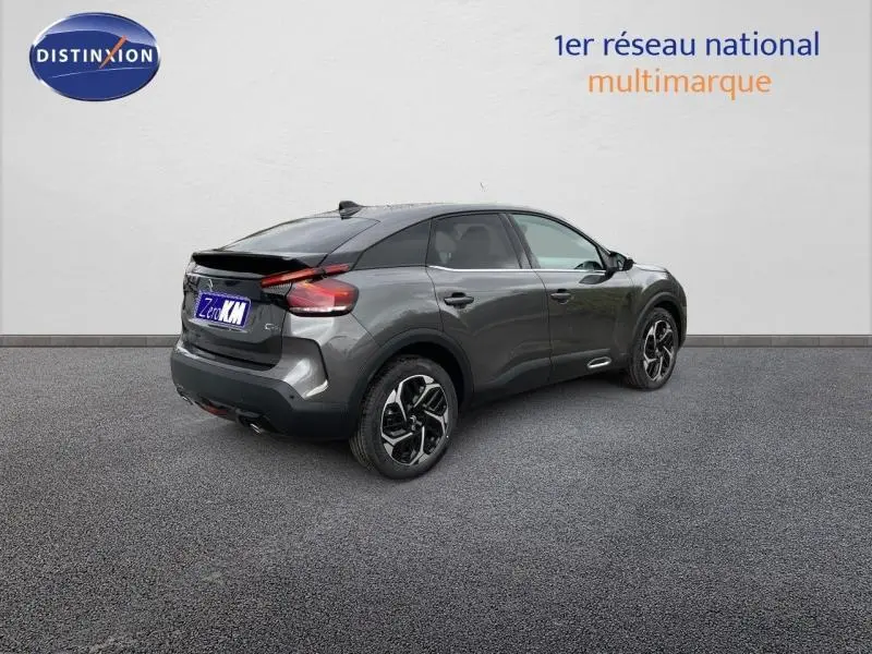 Vue 3/4 arrière droite d'une Citroën C4 2024 gris métallisé avec jantes alliage et feux arrière LED distinctifs.
