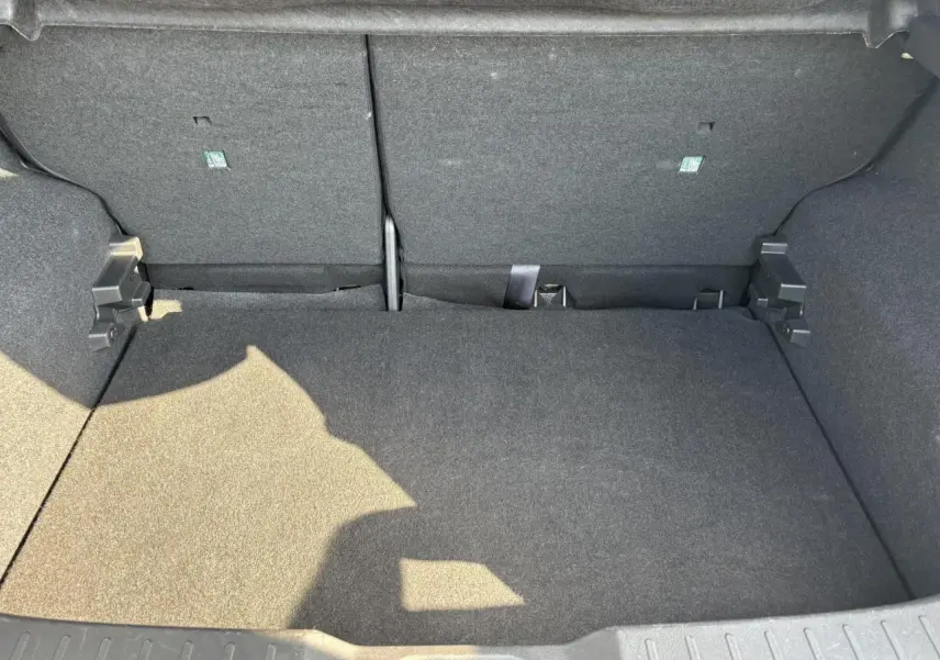 Coffre spacieux du Nissan Juke 2024 gris Dark Metal, vue intérieure arrière avec banquette rabattue.