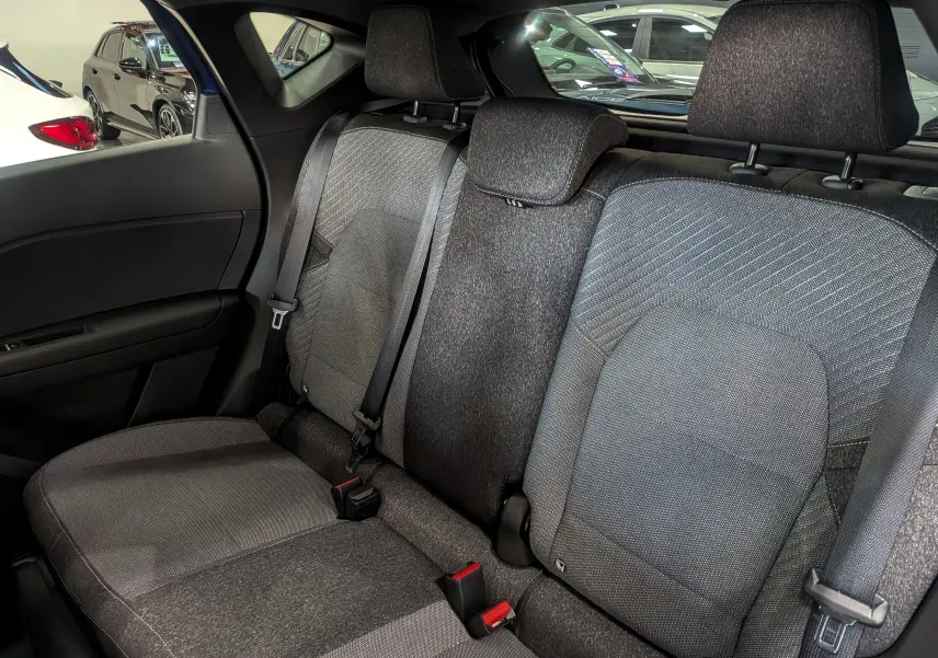 Banquette arrière en tissu gris du Renault Captur 2025, vue côté gauche avec appuie-têtes et ceintures visibles.