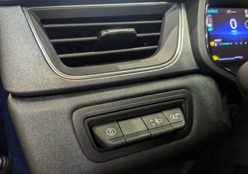 Boutons de commande d'assistance à la conduite sur tableau de bord noir d'un Renault Captur 2025 Mild Hybrid.