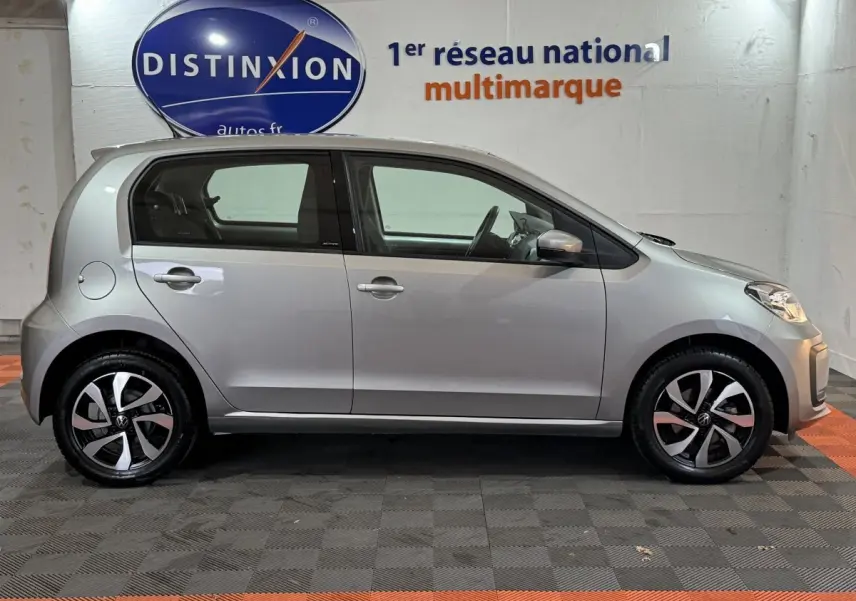 Vue de profil côté gauche d'une Volkswagen Up 1.0 65 Active gris foncé avec jantes alliage et rétroviseurs assortis.