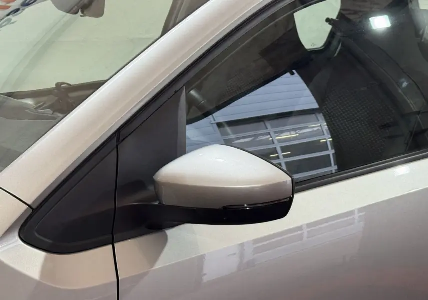 Vue rapprochée du rétroviseur côté gauche d’une Volkswagen Up gris foncé avec caméra intégrée.