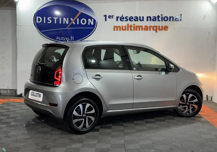 Volkswagen Up 1.0 65 Active gris foncé vue de profil droit en intérieur avec jantes noires et feux arrière LED allumés.