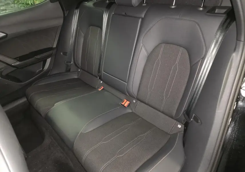Vue intérieure sur la banquette arrière noire en tissu et TEP du CUPRA Formentor 2025, avec ceintures et surpiqûres contrastées.