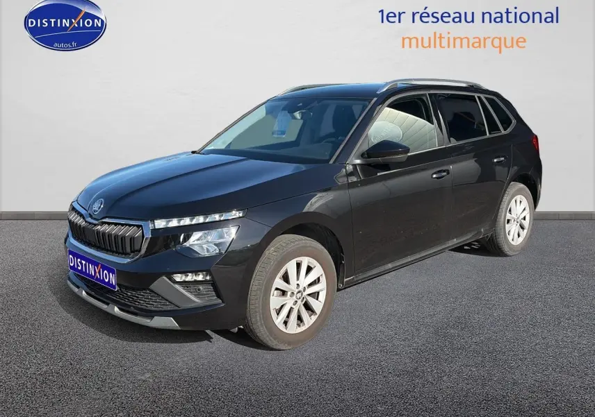 Vue 3/4 avant droit d'un Skoda Kamiq noir avec calandre chromée et jantes alu sur fond neutre.
