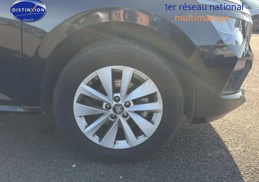 Gros plan sur la roue avant gauche et la jante alu argentée d’un Skoda Kamiq noir, avec partie du pare-chocs avant visible.