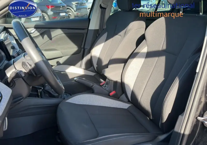 Vue intérieure côté conducteur du Skoda Kamiq noir 2025, mettant en valeur les sièges bi-ton gris et noir et le volant multifonction.
