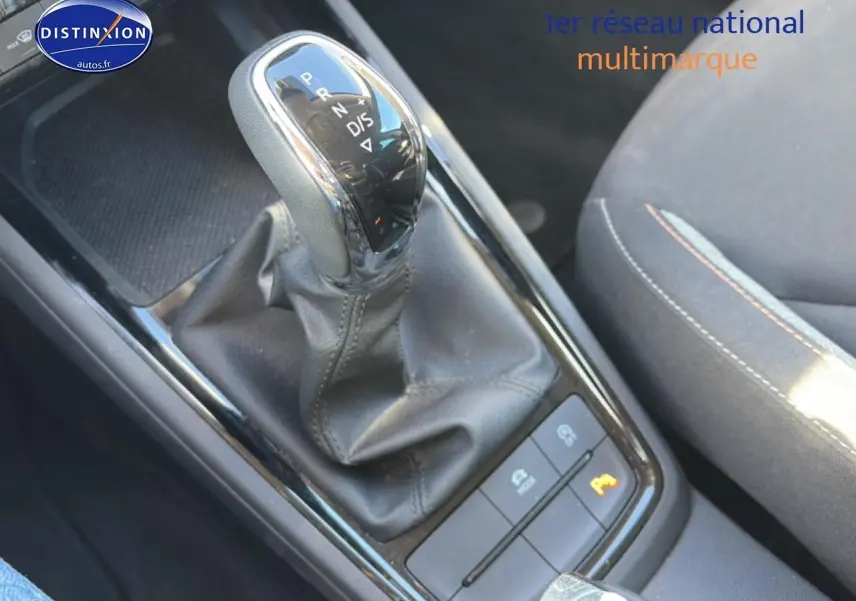 Vue rapprochée du levier de vitesse automatique noir et cuir du Skoda Kamiq 2025, avec siège tissu gris à côté.