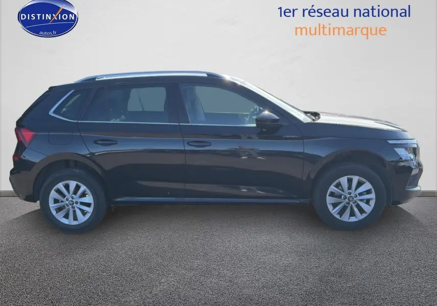 Profil côté gauche d’un Skoda Kamiq noir 2025 avec jantes alliage et barres de toit visibles.