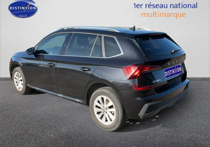 Vue 3/4 arrière droite d’un Skoda Kamiq noir 2025 avec jantes alu et barres de toit visibles.