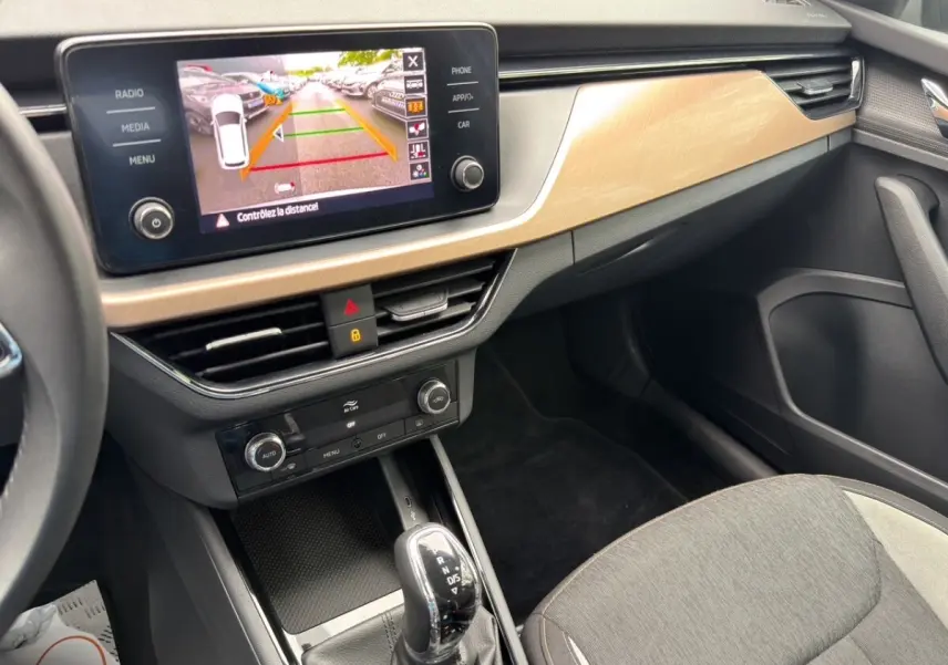 Vue intérieure du tableau de bord et console centrale du Skoda Kamiq 2023 avec écran de recul et levier de boîte automatique.