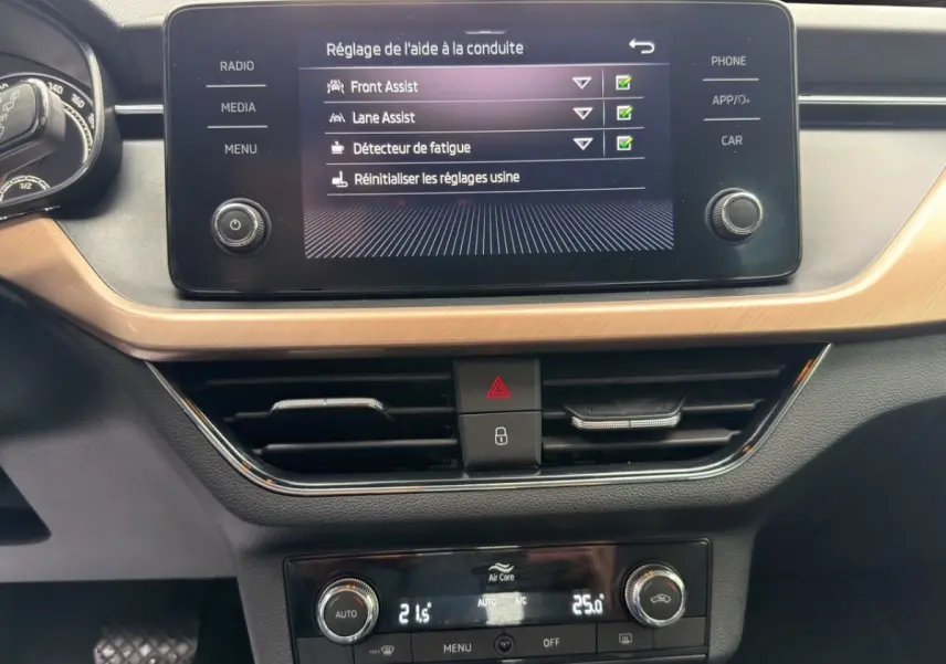 Vue rapprochée du tableau de bord du Skoda Kamiq 2023, écran tactile affichant les aides à la conduite.