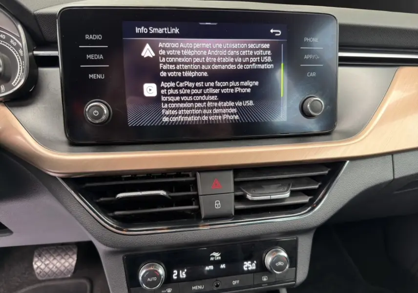 Vue rapprochée de l’écran tactile central et de la console de climatisation du Skoda Kamiq 2023, intérieur noir avec insert bois clair.