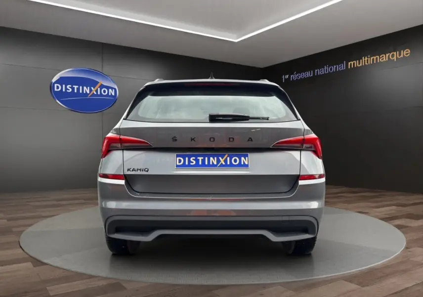 Vue arrière d'un Skoda Kamiq gris foncé avec feux LED et logo distinctif sur fond de showroom.