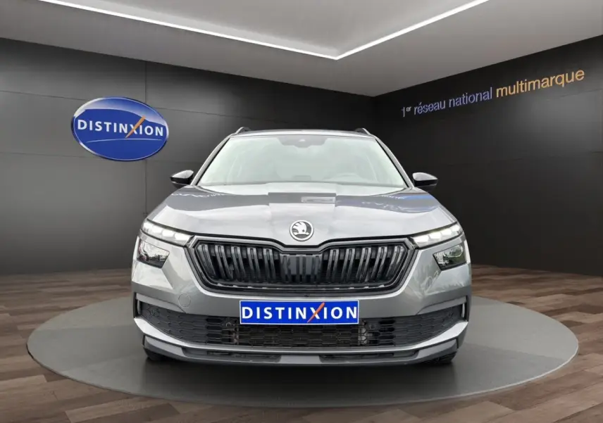Vue frontale d'un Skoda Kamiq gris foncé avec calandre noire et logo centré, présenté en showroom Distinxion.