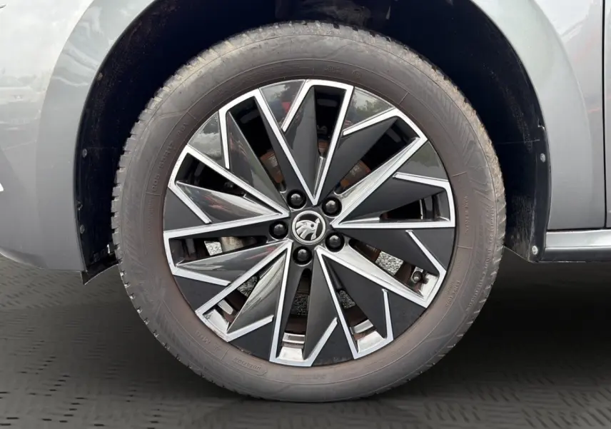 Gros plan sur la jante bi-ton noire et argentée du côté gauche d'un Skoda Kamiq gris foncé 2023.