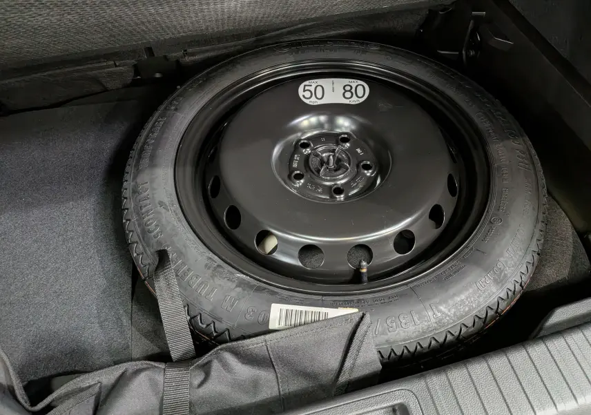 Gros plan sur la roue de secours noire dans le coffre du Renault Captur E-Tech blanc nacré 2026.