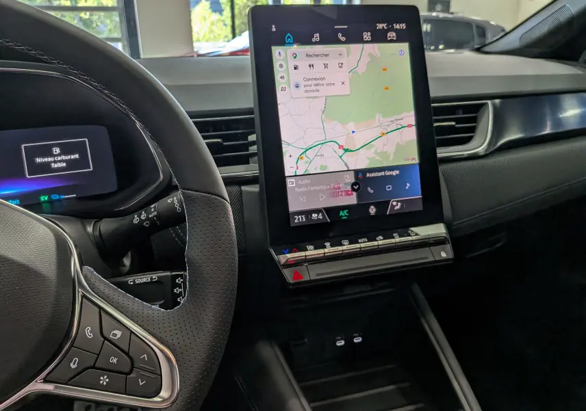 Vue intérieure du tableau de bord du Renault Captur E-TECH 2026, avec écran tactile central affichant une carte GPS.
