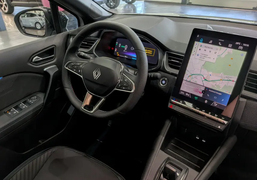 Intérieur Renault Captur E-Tech 2026 vu côté conducteur, volant cuir, tableau de bord digital et écran tactile vertical.