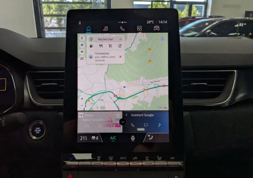 Vue rapprochée de l’écran tactile central du Renault Captur E-TECH 2026, affichant la navigation GPS et les commandes climatisation.