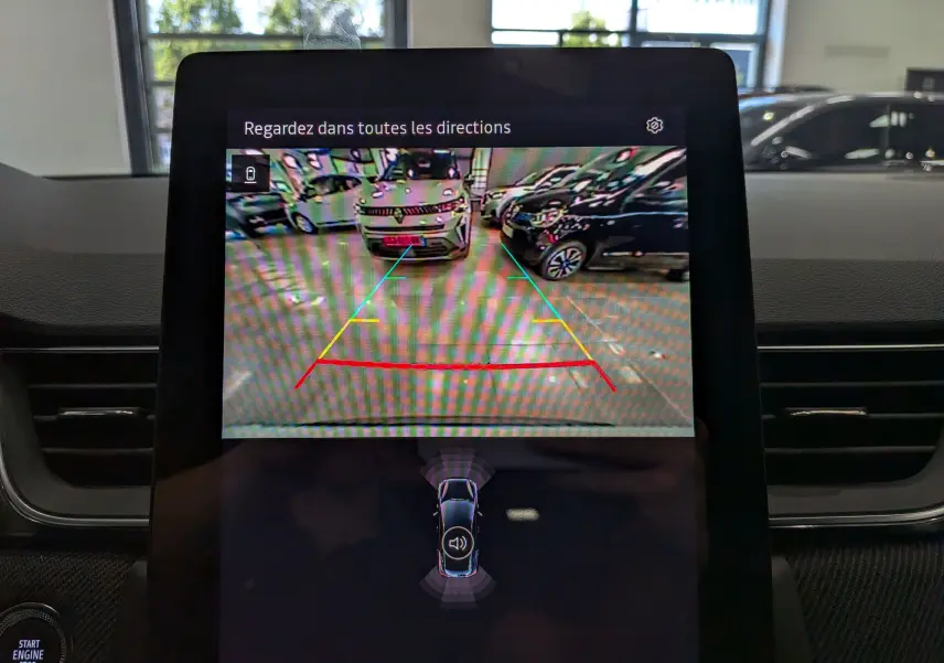 Écran de caméra de recul du Renault Captur E-TECH blanc nacré avec toit noir, affichant l'arrière en intérieur.