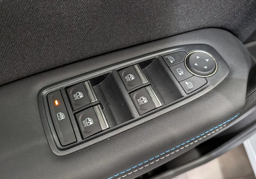 Gros plan sur les commandes des vitres et rétroviseurs côté conducteur du Renault Captur E-TECH blanc nacré, avec surpiqûres bleues.
