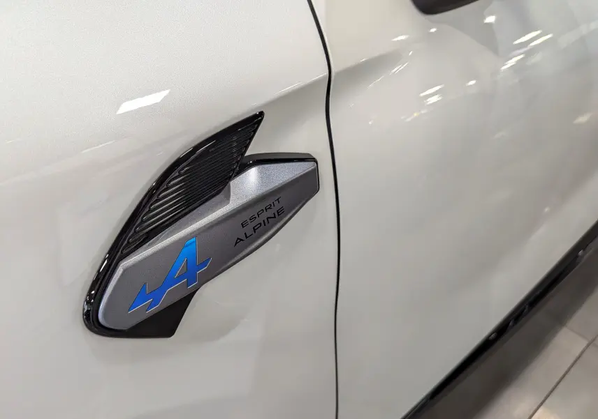 Détail de l'aile avant gauche du Renault Captur blanc nacré avec logo Esprit Alpine bleu et noir.